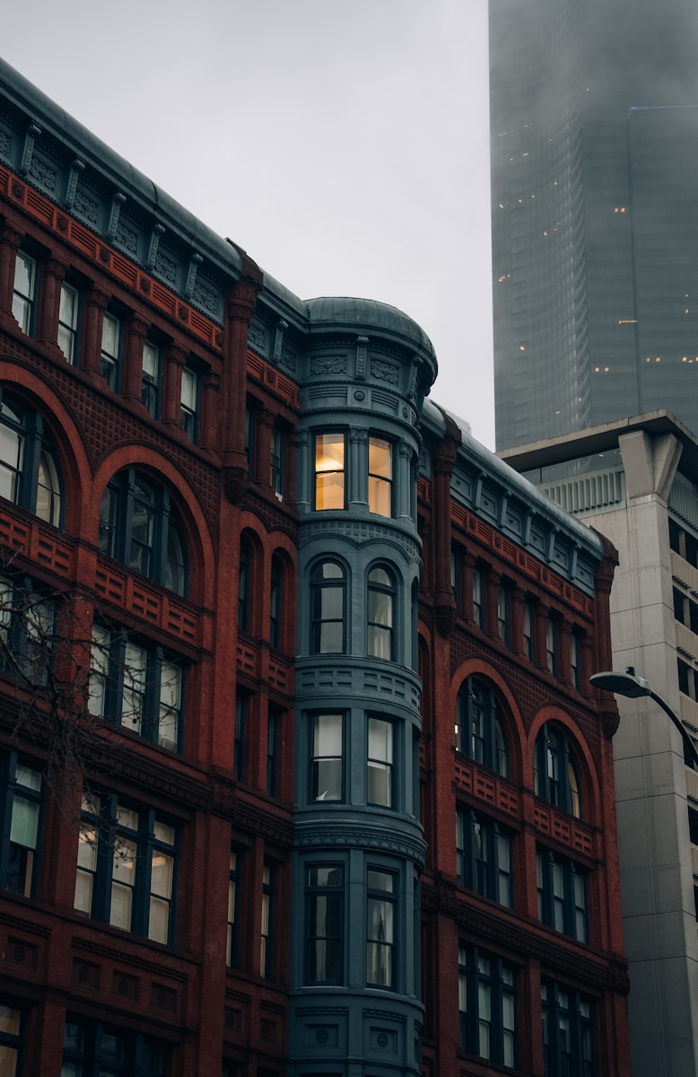 A tall red brick building next to a tall building